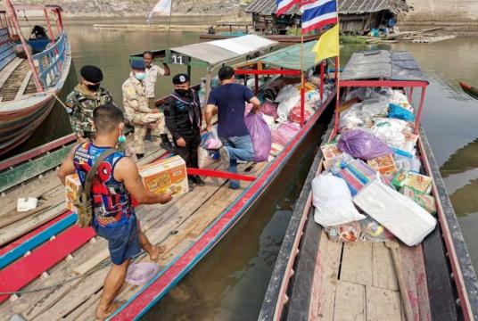 Donated rations for Myanmar refugees being loaded onto a boat in a Thai village near the Myanmar border last week. The writer says the Thai foreign policy establishment needs to be more assertive in persuading the military to allow Myanmar refugees into the country.PHOTO: EPA-EFE