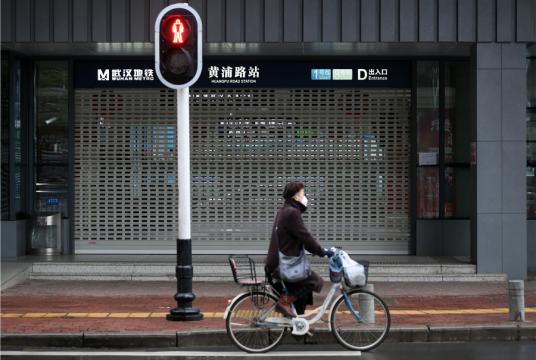 A resident rides past the closed Huangpu Road metro station in Wuhan, Hubei province, on Jan 25, 2020. [Photo by Zhou Guoqiang/for chinadaily.com.cn]