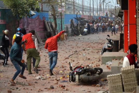 People supporting a new citizenship law and those opposing the law, throw stones at each other during a clash in Maujpur area of New Delhi, India, February 