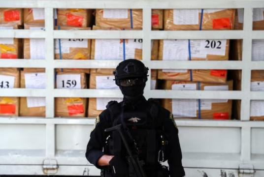 A police officer from the Narcotics Control Board stands guard in front of boxes of confiscated drugs during the 50th Destruction of Confiscated Narcotics ceremony in Ayutthaya province, Thailand, June 26, 2020. REUTERS/Athit Perawongmetha/File Photo