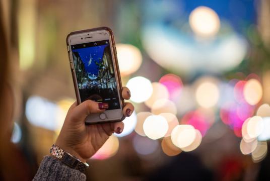 A person takes a photo with a smartphone of Christmas lights at Carnaby Street in the Soho district in London, Britain, Dec 7, 2019. [Photo/Agencies]