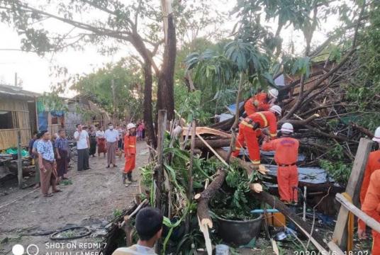 Firefighters clear away the debris from the strong wind