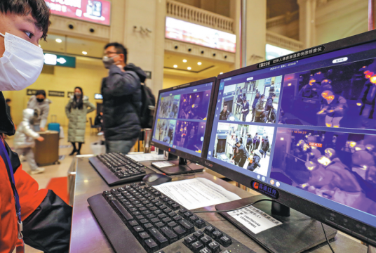 An employee of Hankou Railway Station in Wuhan, Hubei province, identifies a passenger with fever, on a computer screen showing the person's body temperature as 38.4 C. Travelers with fever at the train station are asked to register and are provided with medical assistance. YUAN ZHENG/FOR CHINA DAILY