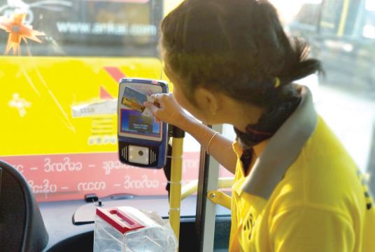 A staff member demonstrates how to use payment card 