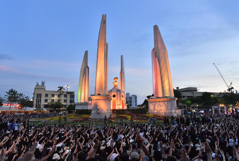 Anti-government protesters hold up three-finger salutes at a rally by the Democracy Monument in Bangkok on August 16, 2020. 