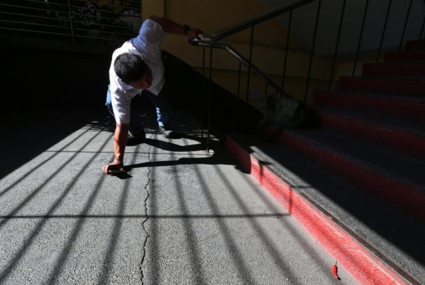 Security officer Julian Vargas Jr. inspects cracks on the stairs of a building at Tondo High School after the 6.1-magnitude earthquake on April 22. Experts say there is no such thing as “earthquake-proof” structures. —LYN RILLON