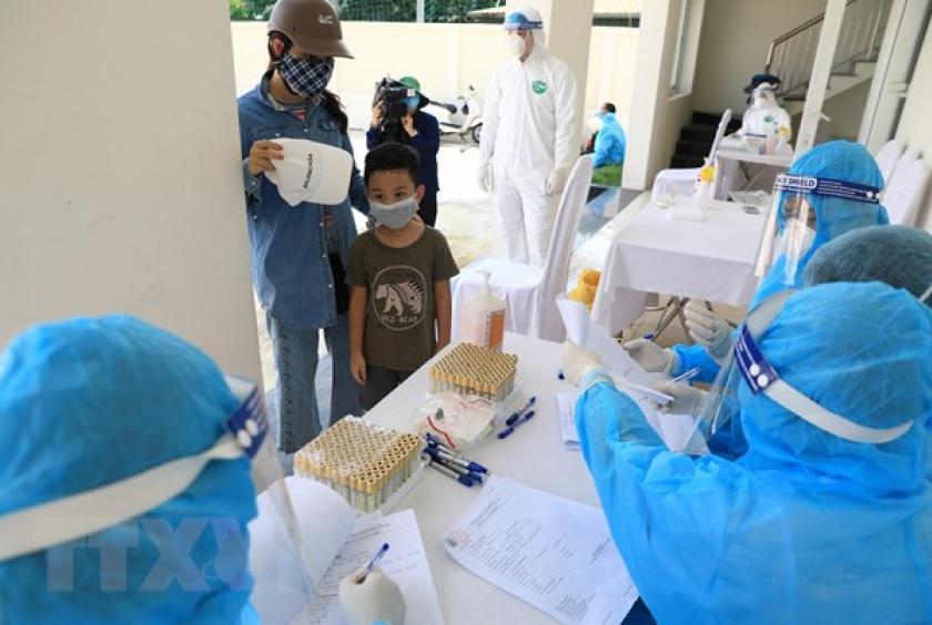 Residents returning from Đà Nẵng City have their blood sample taken for COVID-19 testing at a station in Hà Nội. The city is striving to quickly complete the implementation of RT-PCT testing for all people who visited Đà Nẵng and returned to Hà Nội from July 15-29.—VNA/VNS Photo Thành Đạt