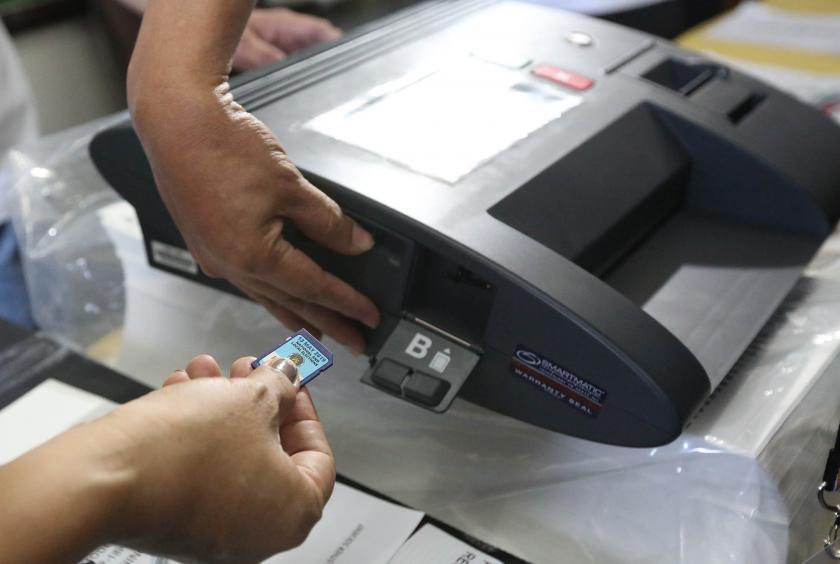 SD cards are inserted into a new vote counting machine at San Jose Elementary School in Makati City after a defective VCM delayed proceedings on election day on Monday. —MARIANNE BERMUDEZ/Philippine Daily Inquirer