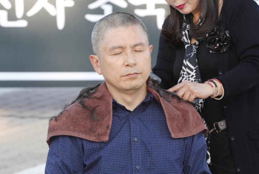 Hwang Kyo-ahn, chairman of the main opposition Liberty Korea Party, has his hair shaved at a plaza in front of Cheong Wa Dae in Seoul on Monday, calling for the resignation of Justice Minister Cho Kuk (Yonhap)