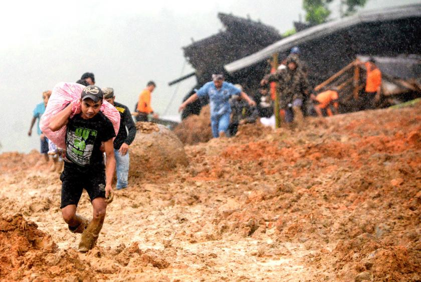 Residents flee their homes as rescue workers search for survivors at the site of a landslide in Sukabumi, West Java. The landslide, which was triggered by heavy rain, left at least nine people dead and dozens missing. (AFP/-)