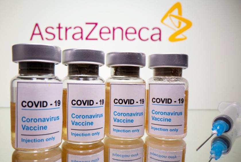 Vials with a sticker reading, "COVID-19 / Coronavirus vaccine / Injection only" and a medical syringe are seen in front of a displayed AstraZeneca logo in this illustration taken October 31, 2020. (Yonhap-Reuters)