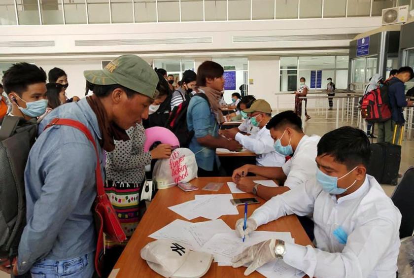 Migrant workers from Myanmar fill out information at the Myawaddy border office after passing through border gate at Myawaddy, Myanmar, after leaving Thailand due to the coronavirus disease (COVID-19) outbreak, in this image obtained via social media. (REUTERS/THANT ZIN AUNG)