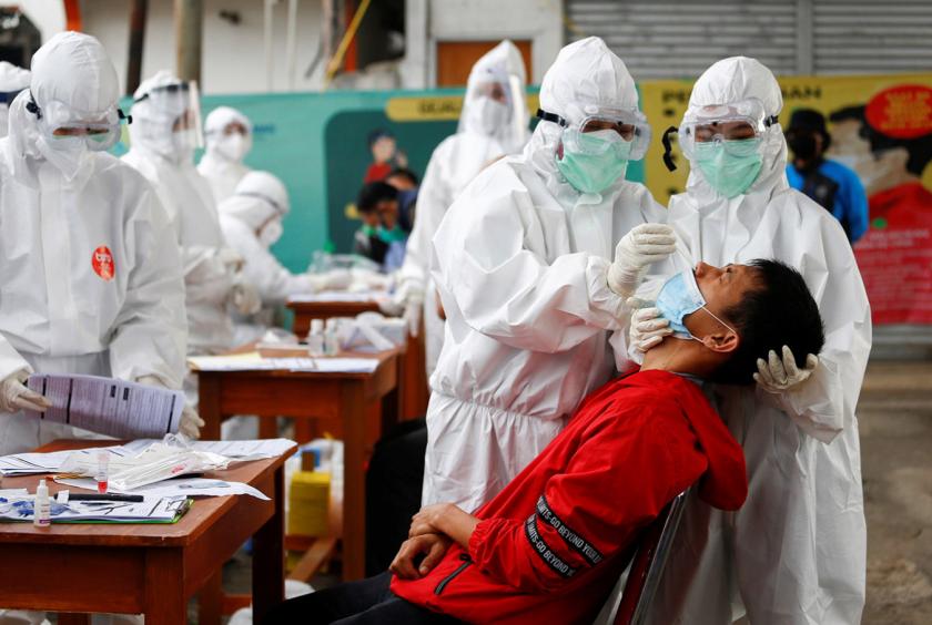 Healthcare workers take a swab sample from a passenger being tested for COVID-19 at a train station in Bogor, West Java, on May 11. (REUTERS/Ajeng Dinar Ulfiana)