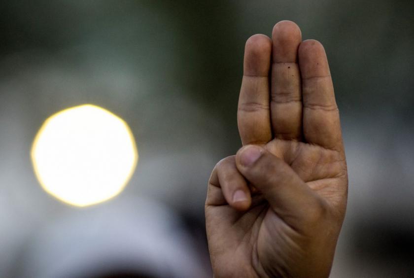 A protester performs the three-finger salute as Myanmar migrants living in Thailand take part in a rally outside the United Nations ESCAP building in Bangkok on March 5, calling for the release of political prisoners following the military coup in their homeland. (AFP/Jack Taylor)