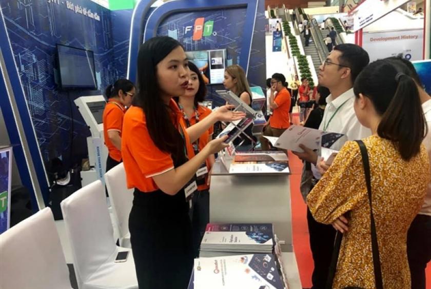 A staff of FPT Group introduces the latest technology to visitors at the Industry 4.0 exhibition in the National Convention Centre in Hà Nội. — VNS Photo Thu Giang