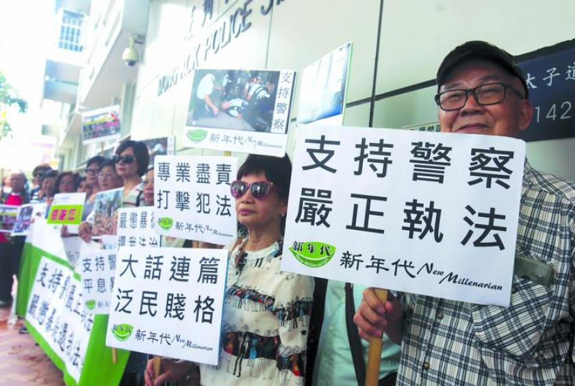 Displaying placards reading "Supporting police law-enforcement action" outside the Mong Kok police station on June 19, Hong Kong residents back the police force after radical protesters opposing the government’s extradition law amendment bill clashed with officers. (PARKER ZHENG / CHINA DAILY)