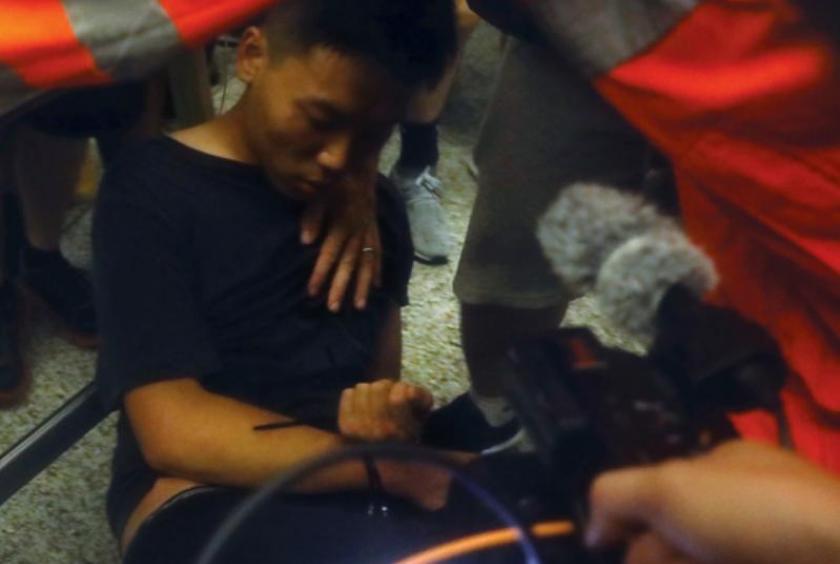 A man accused by rioters of being an undercover police officer appears to be unconscious after being beaten up and denied access to medical attention at Hong Kong International Airport, in the night on Aug 13, 2019. (PHOTO / CHINA DAILY)