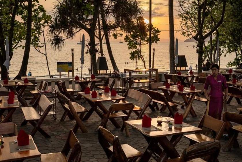 This photo taken on Feb 6, 2020 shows a waitress cleaning an area at a nearly empty restaurant at Ao Nang beach in Krabi province, Thailand. (NICOLAS ASFOURI / AFP)
