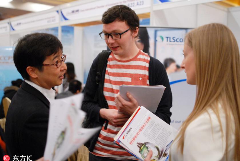 Foreign job seekers talk with an interviewer at a job fair in Beijing, April 7, 2012. [Photo/IC]