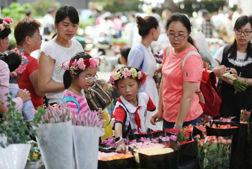 Shoppers examine flowers at florists in Kunming, capital of Yunnan province. [Photo by Yang Zheng / For China Daily]