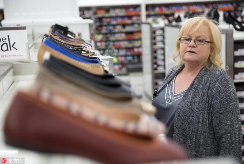 A woman shops the shoe department at the new Century 21 department store in Philadelphia, Oct 28, 2014. [Photo/IC]