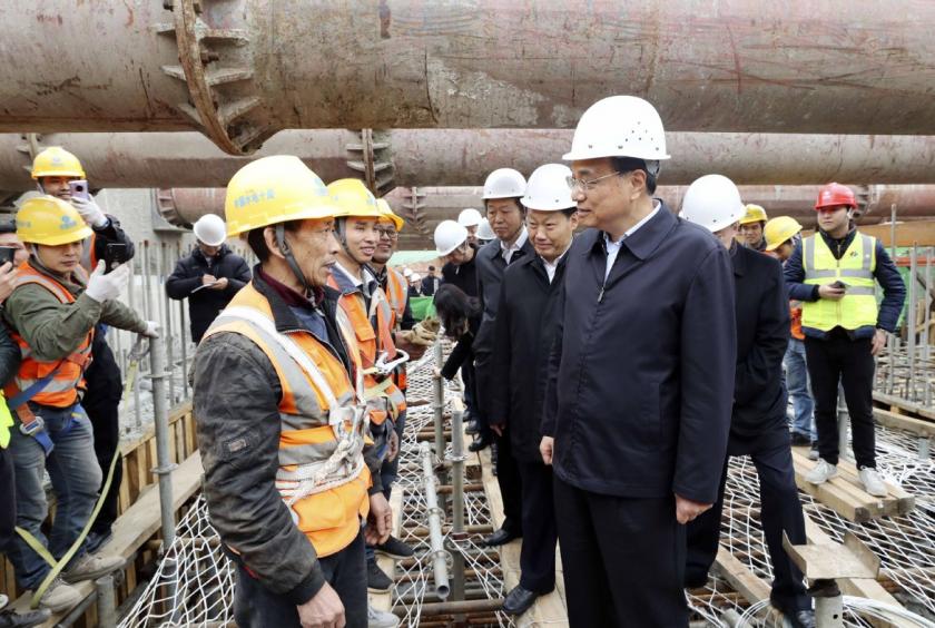 Premier Li Keqiang, visiting a construction site on Monday in Chengdu, Sichuan province, talks with migrant workers after climbing up a scaffold. He asked them about their monthly earnings and the length of their workday. He also asked whether their wages are paid on time and in full. YAO DAWEI/XINHUA 