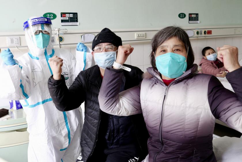 A 67-year-old man surnamed Wan and his wife, both previously infected with novel coronavirus, were discharged on Friday from a hospital in Wuhan. A doctor celebrates with the couple in a ward. [Photo by Gao Xiang/provided to chinadaily.com.cn]
