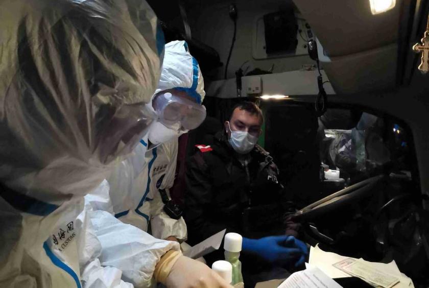 Customs officials show a motorist how to fill in his health declaration after he crossed the China-Russia border on April 6 at Manzhouli, in the Inner Mongolia autonomous region. [LUAN TAO/FOR CHINA DAILY]