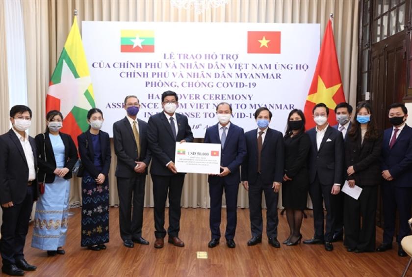 Deputy Foreign Minister Nguyễn Quốc Dũng presents the Vietnamese Government's gift to Myanmar Ambassador Kyaw Soe Win in Vietnam at a ceremony held on Friday in Hanoi. — VNA/VNS Photo 