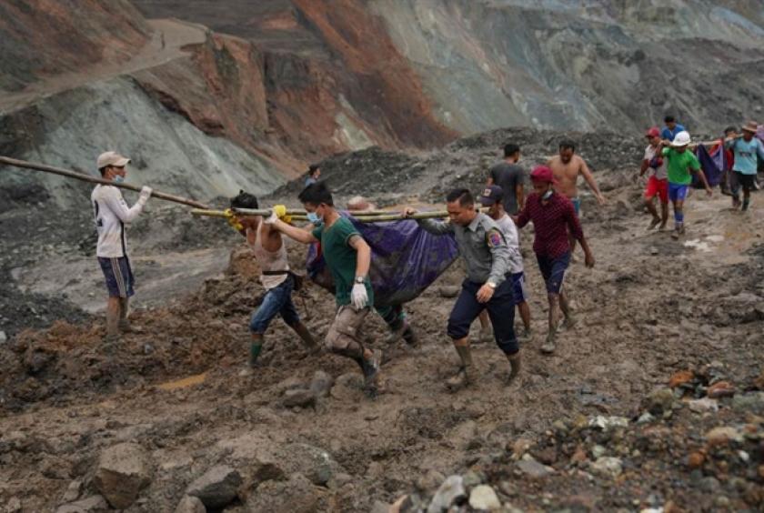Rescuers pulling out mud-slaked bodies from the jade mine in Hpakant, Myanmar, after the landslide on Thursday.—AFP/VNA Photo