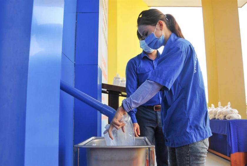 A worker gets free rice from a rice ATM set up during COVID-19 pandemic to support poor people and workers at Suối Dầu Industrial Zone in the central province of Khánh Hoà. — VNA/VNS Photo Phan Sáu
