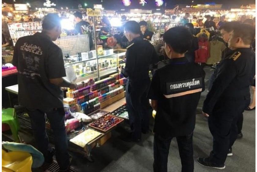 Officials from the Department of Disease Control’s Bureau of Tobacco Control and Office of the Consumer Protection Board arrest vendors selling ecigarettes and nicotine chargers last month at the Liab Duan night market in Bangkok’s RamIndra area./The Nation