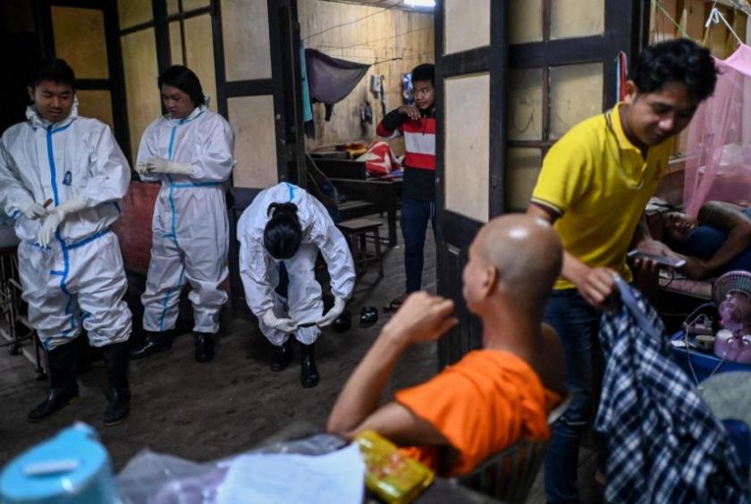 Medical volunteers putting on personal protective equipment before leaving their temporary base in Taungoo district, in Myanmar's Bago region, on Aug 7, 2021.PHOTO: AFP