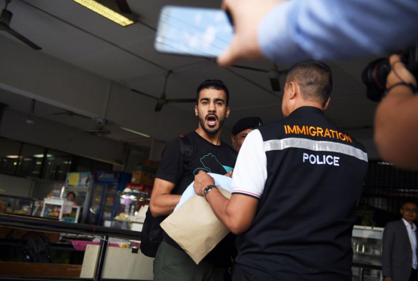Hakeem Alaraibi (C), a former Bahrain national team footballer with refugee status in Australia, is escorted by immigration police to a court in Bangkok on December 11, 2018. // AFP PHOTO