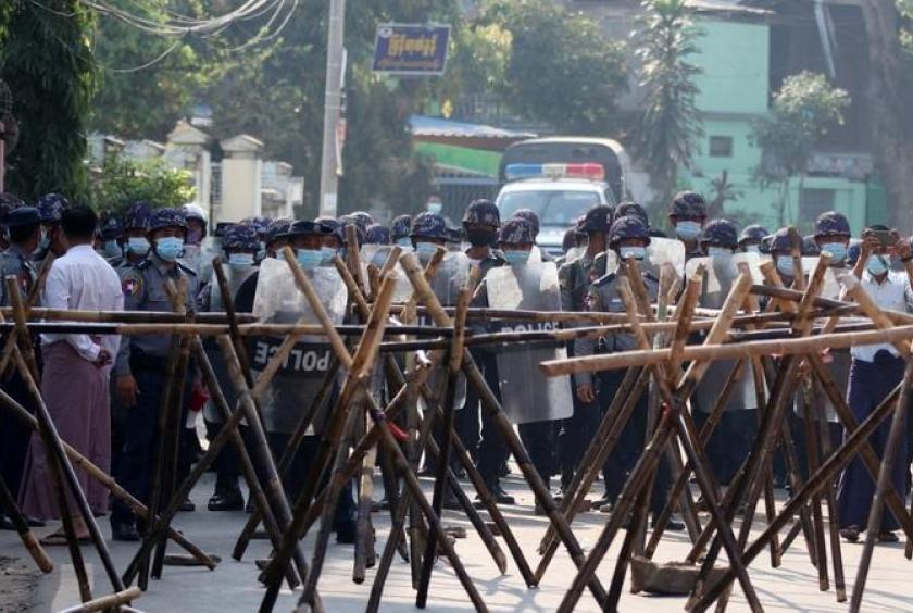 Riot police approach protesters' barricade in an attempt to disperse demonstration against the military coup in Naypyidaw, Myanmar on March 4, 2021. (STR / AFP)