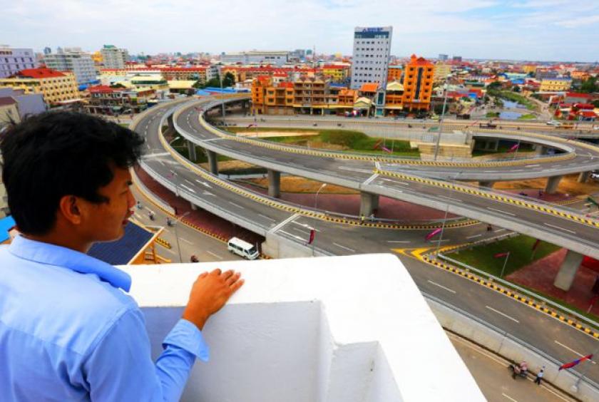 A young man looks down at the Stung Meanchey flyover. Heng Chivoan