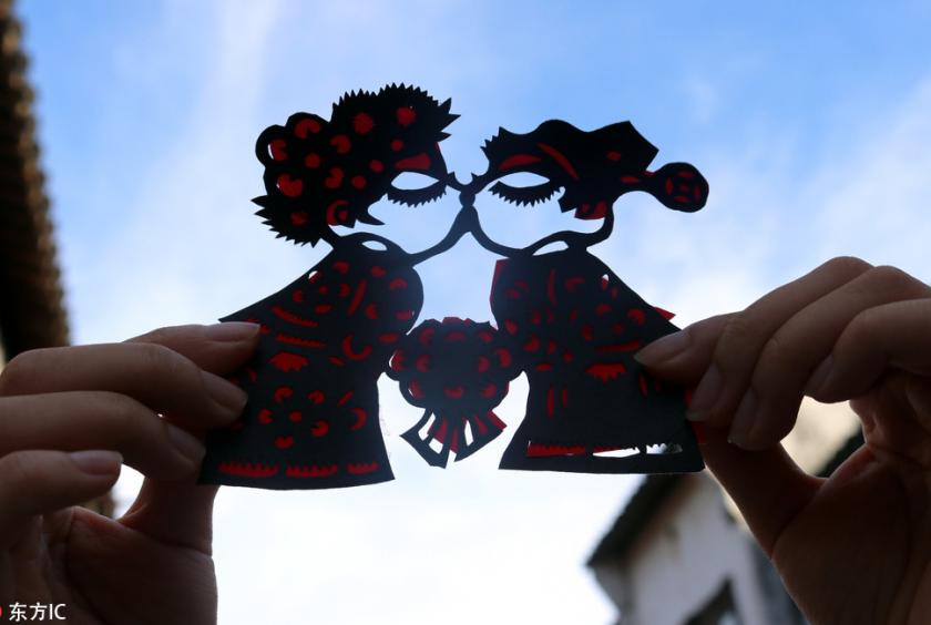 A tourist displays a paper-cut made by a Chinese folk artist for the upcoming Qixi Festival, or the Chinese Valentine's Day, in Suzhou city, East China's Jiangsu province, on Aug 14, 2018. [Photo/IC]