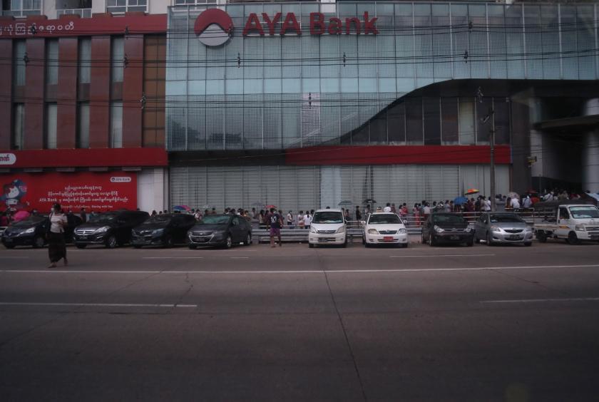 People queue up for the ATM along Strand Road in Yangon. (Photo - Thiha Aung)