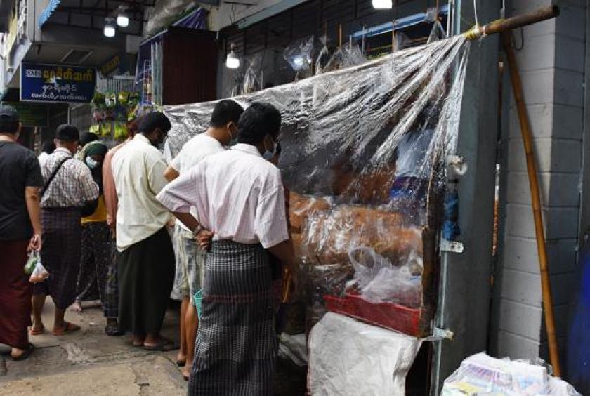 Crowds of people seen buying from a shop of a retail market in Yangon Region