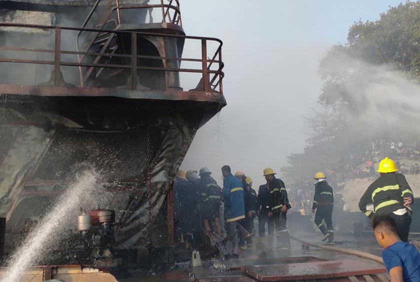 Firefighters are trying to put out the fire on cargo vessel.