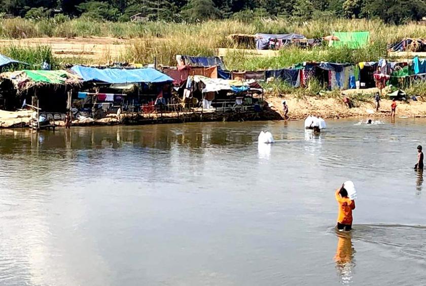 Members of an aid organization from Thailand seen crossing the river to send food packages to the IDPs on Myanmar side. (Photo-Ko Gyi Mann) 
