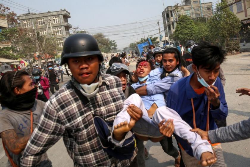 People carry an injured demonstrator during a protest against the coup in Mandalay, on March 22, 2021.PHOTO: EPA-EFE