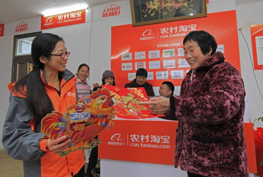 A villager in Ninghai county, Zhejiang province, receives New Year celebration decorations at a rural Taobao shop. [Photo by Zhang Yongtao/For China Daily]