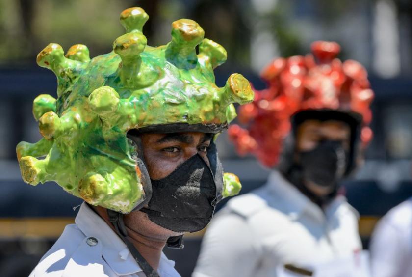 Traffic police personnel wearing coronavirus-themed helmets participate in a campaign to educate the public during a government-imposed nationwide lockdown as a preventive measure against the COVID-19 coronavirus in Bangalore on March 31, 2020. (Photo by Manjunath Kiran / AFP)
