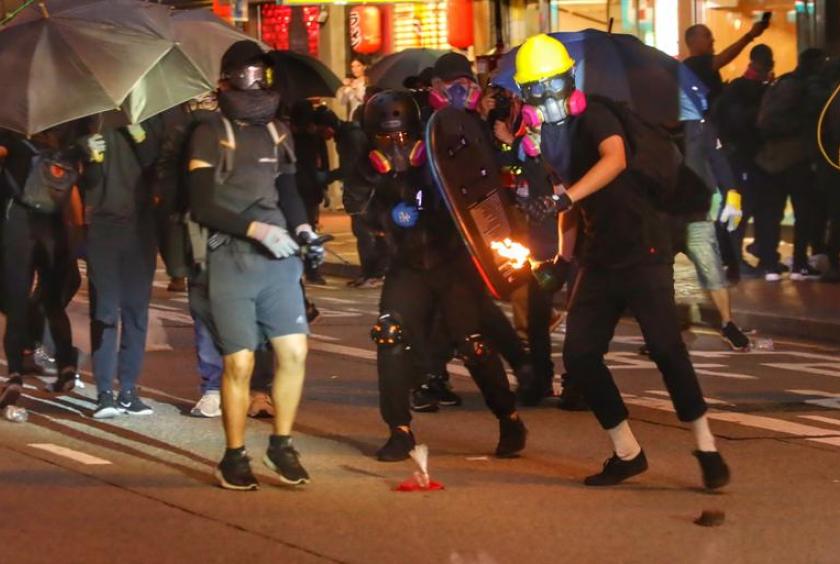 A rioter throws a gasoline bomb at police in Wan Chai. [PHOTO/CHINA DAILY]