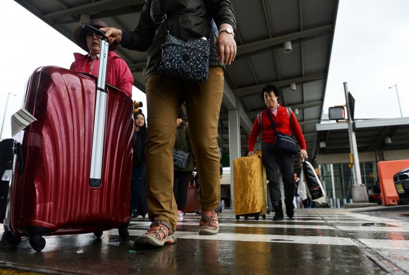 Arriving passengers make their way from Terminal 4 at the JFK airport in New York on October 11, 2014. US authorities have said they would start screening at three airports to detect travelers arriving via direct or connecting flights from Wuhan who may have symptoms of the new virus. (AFP/Jewel Samad)