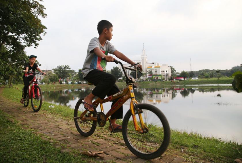 Two children ride bicycles along a path near a man-made lake in Jatisampurna, Bekasi, West Java, just before 'maghrib' on May 6, the first day of Ramadan in Indonesia. (The Jakarta Post/P.J.Leo ) 