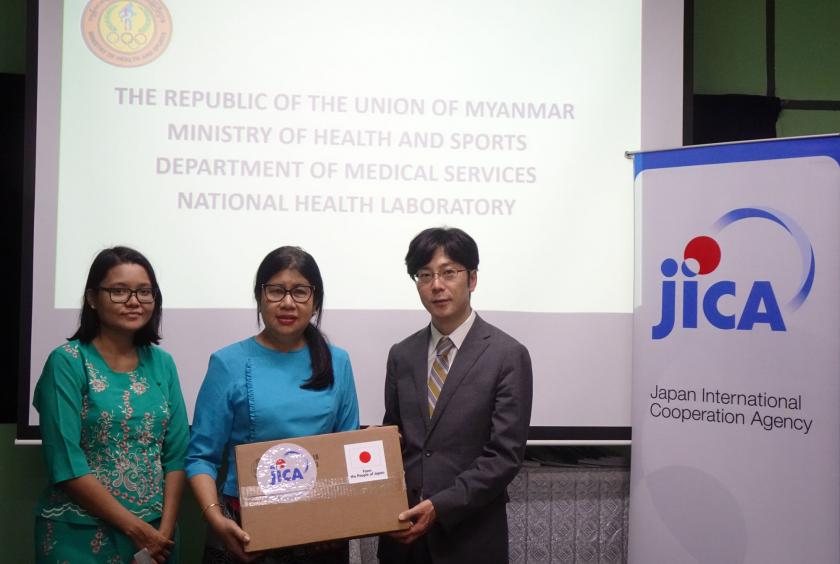 A JICA official hands over lab equipment