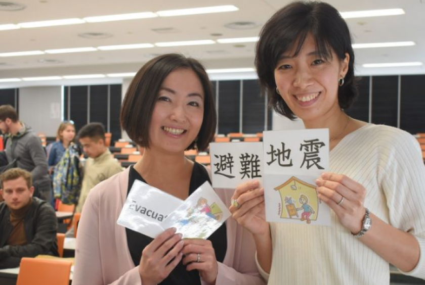 Jiji Press  Motoko Kimura, left, shows cards used to teach disaster-related terms, at Tokyo International University in Kawagoe, Saitama Prefecture, on March 26.