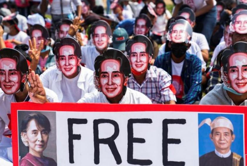 Protesters wearing masks depicting ousted leader Aung San Suu Kyi, flash three-finger salutes as they take part in a protest against the military coup in Yangon, Myanmar, February 28, 2021. Reuters